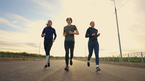 Un-Grupo-De-Tres-Corredores-Corren-En-El-Entrenamiento-Matutino-Antes-Del-Deporte-Profesional-De-Maratón.